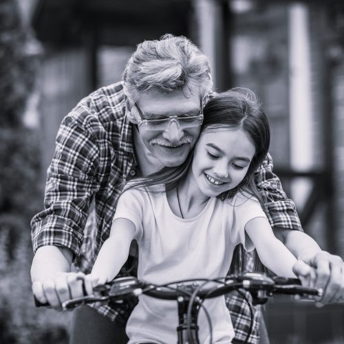 Une petite fille et son grand-père en vélo